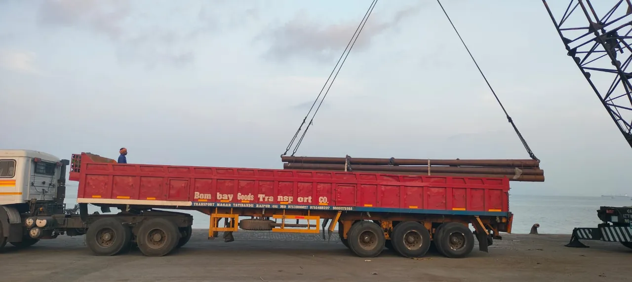 Steel pipes being loaded onto a trailer at the port