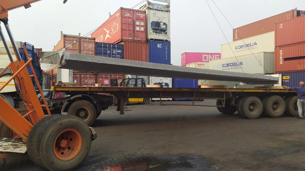 Long steel plate loaded on a trailer in a container yard