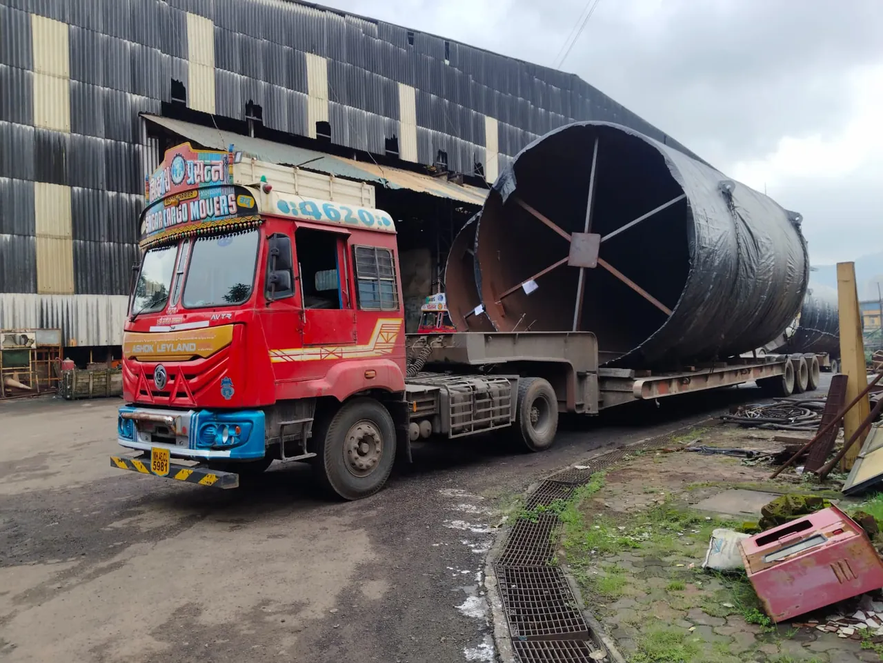 Truck carrying large cylindrical steel cargo on a low-bed trailer