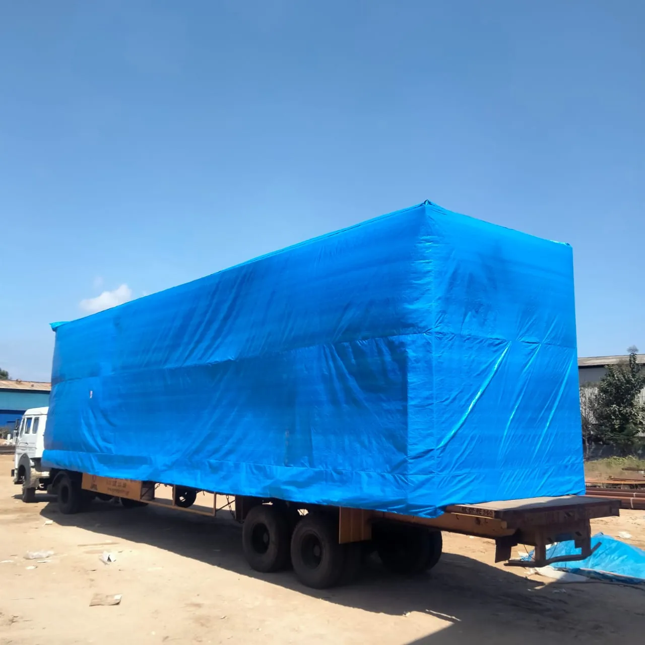 Oversized cargo covered in a blue tarpaulin on a trailer