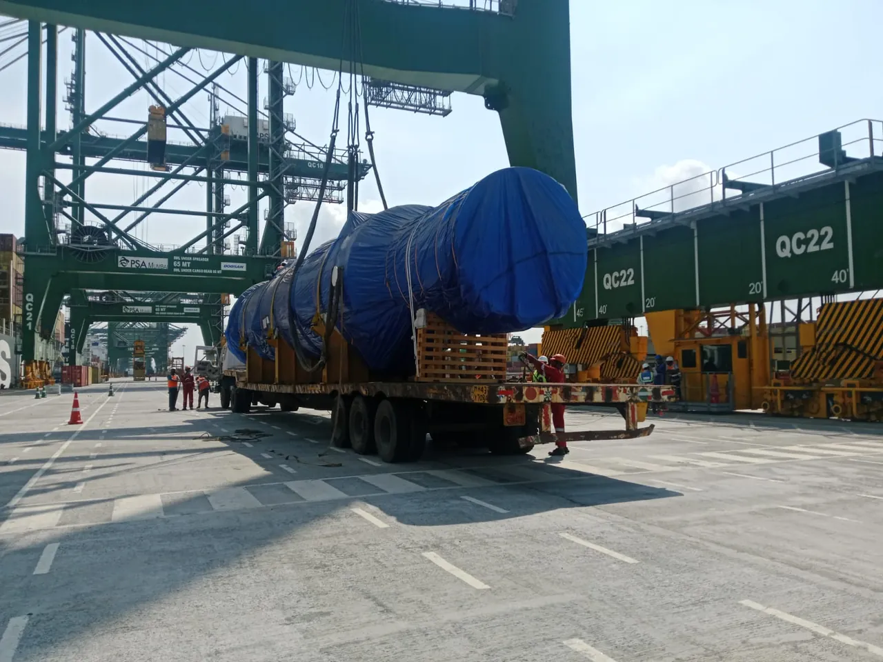 Large wrapped cylindrical cargo being lifted at a container terminal
