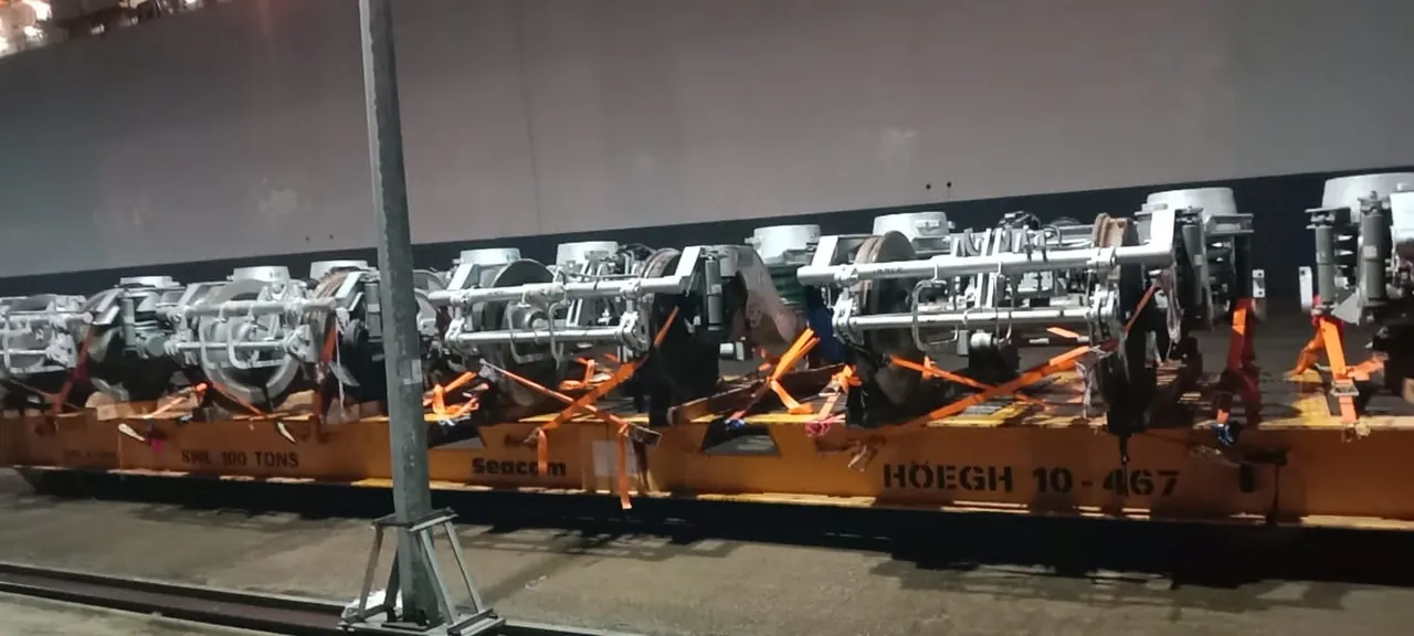 Railway bogies secured with lashing straps on a flat rack at the port