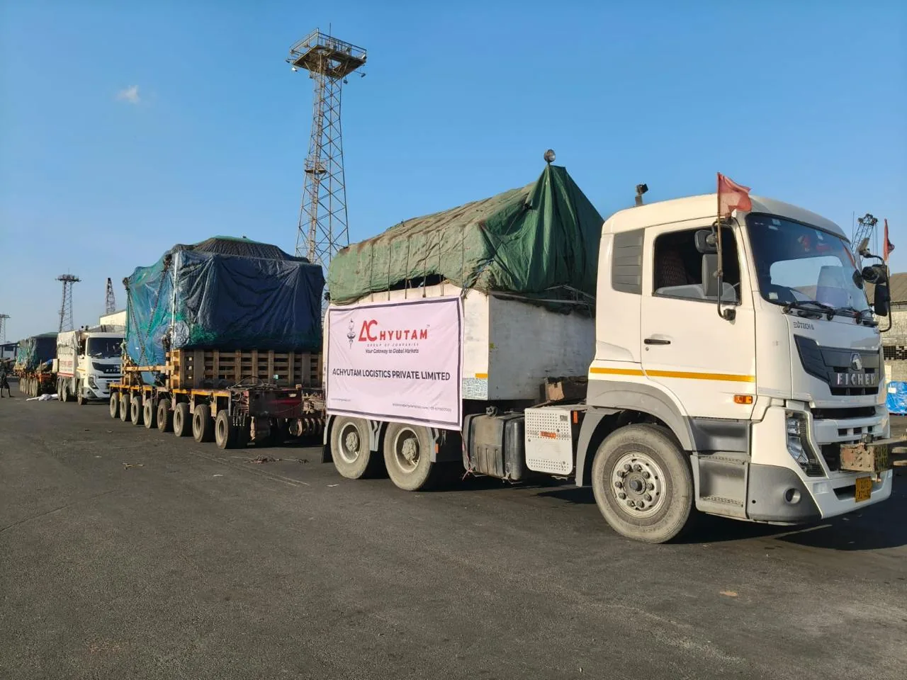 Convoy of trucks and trailers carrying project cargo at the port